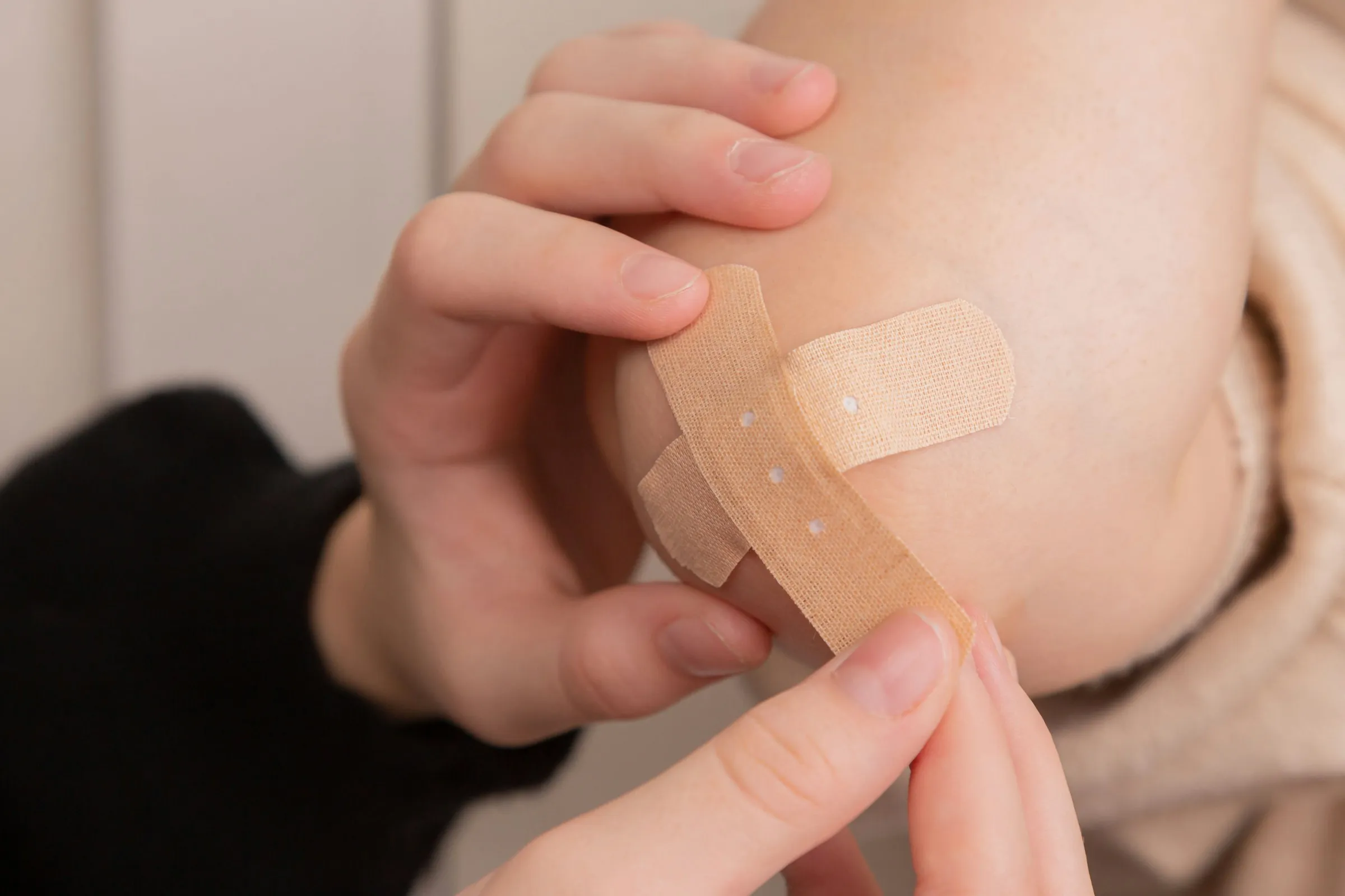 Anlegen eines Pflasters am Arm als praktische Übung zur Wundversorgung