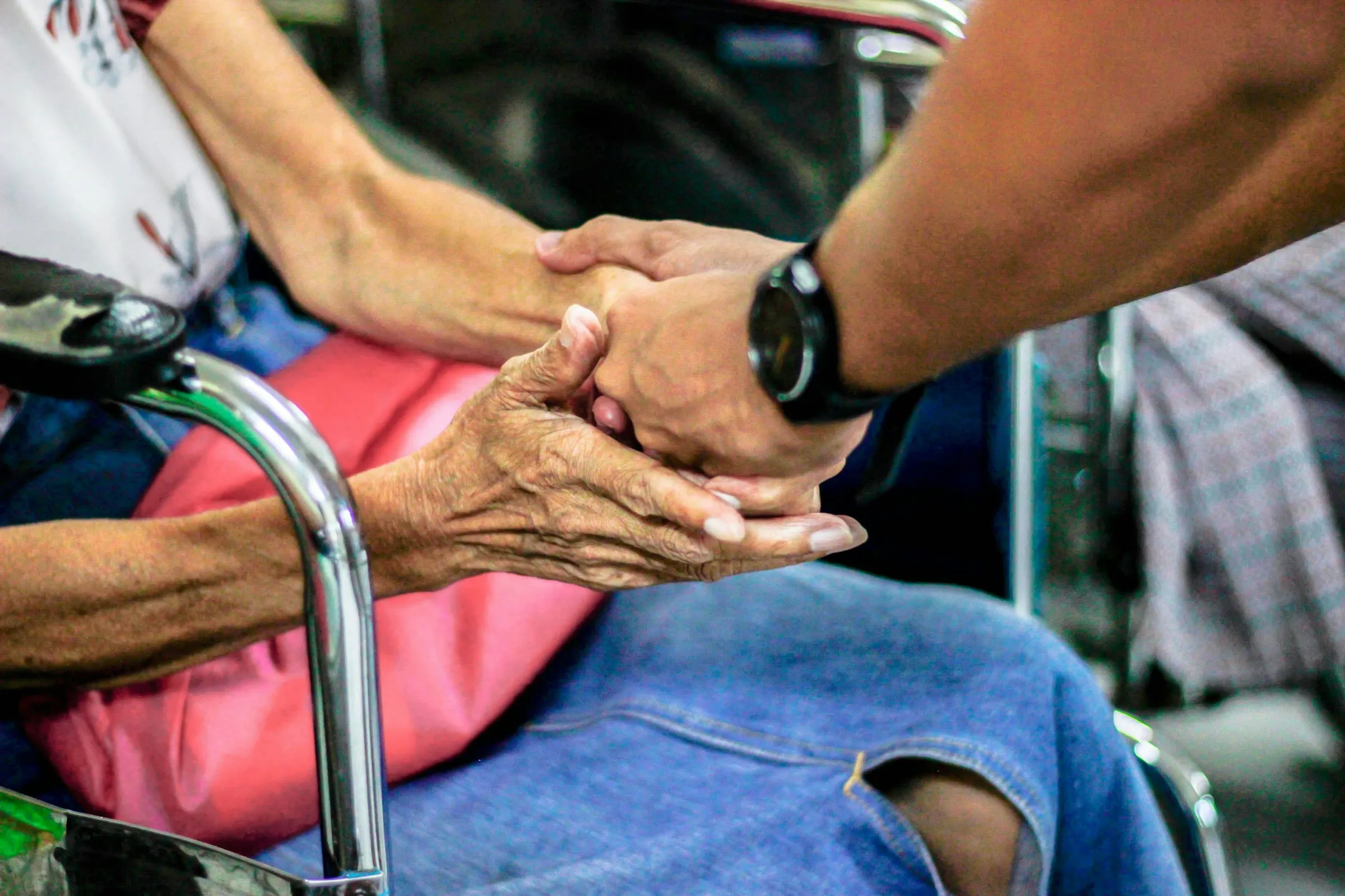 Eine helfende Hand hält beruhigend die Hand einer anderen Person