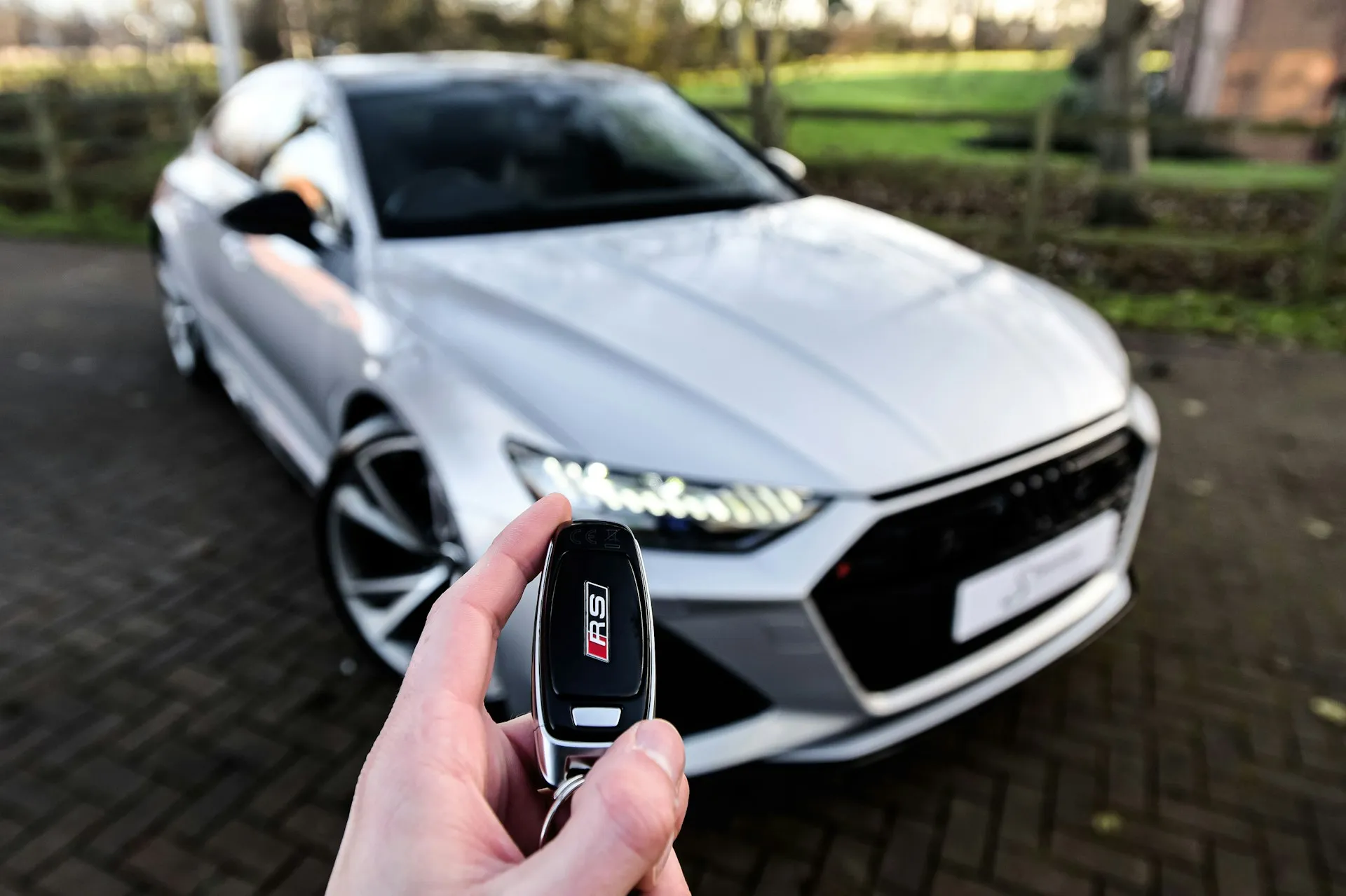 Autoschlüssel vor einem Auto – bereit für den ersten eigenen Wagen